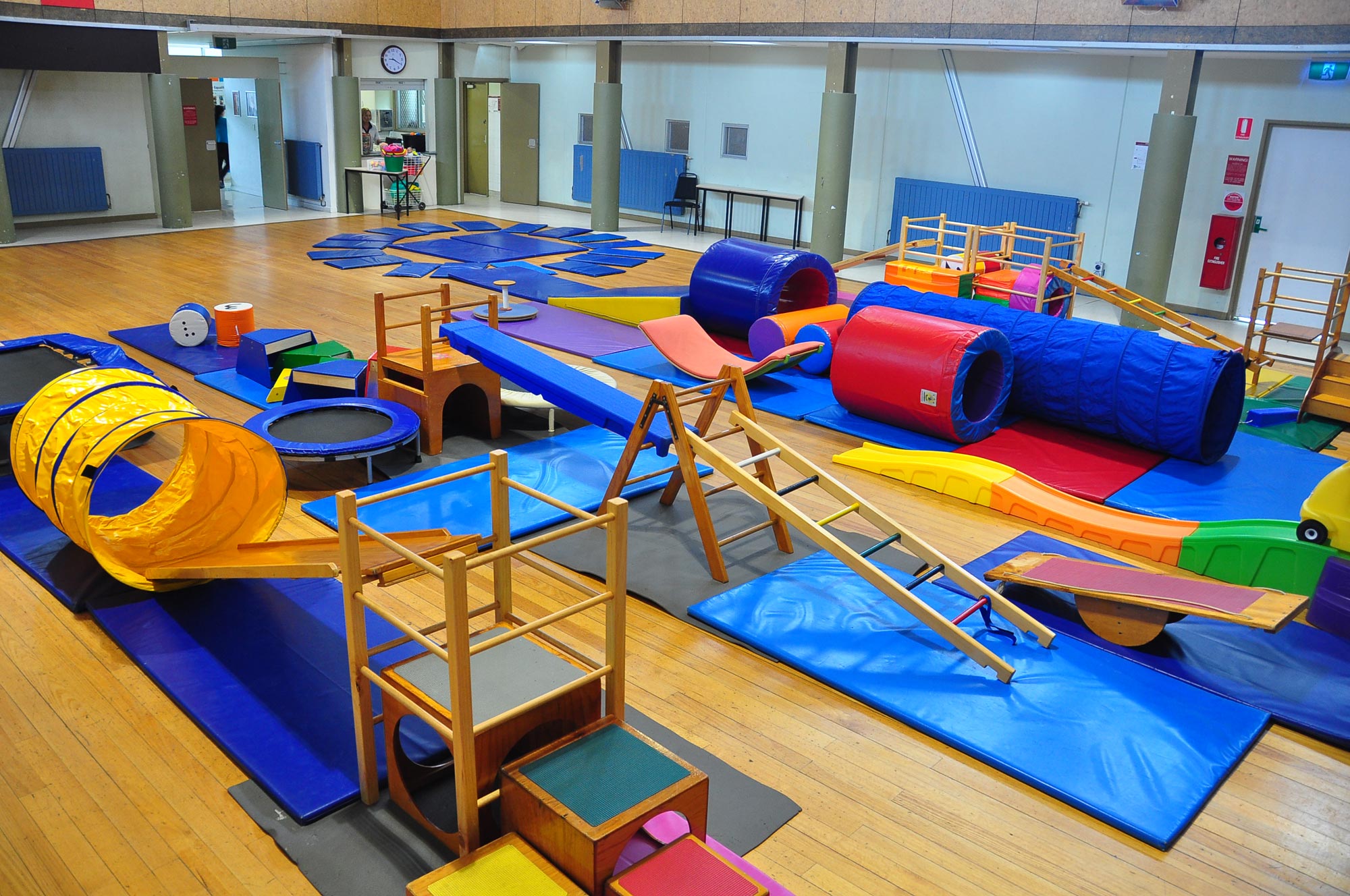 Colourful children's play equipment set up in a hall