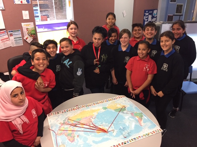 Group of school children gathered around large map