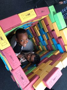 Children sitting amongst toy building blocks