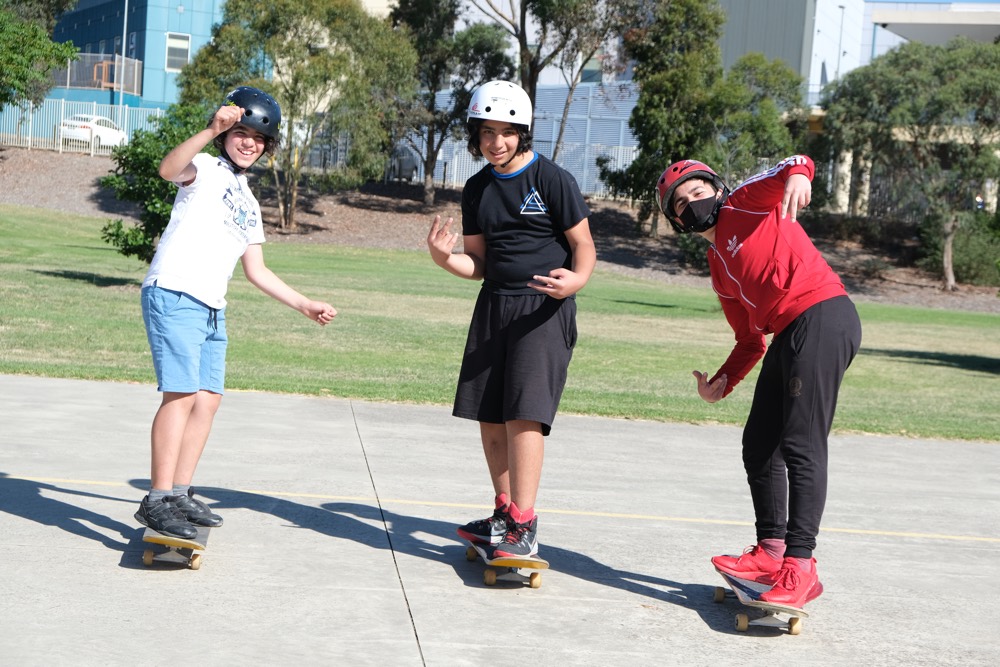 Three young people learning to skateboard