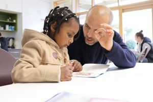 Man tutoring young girl